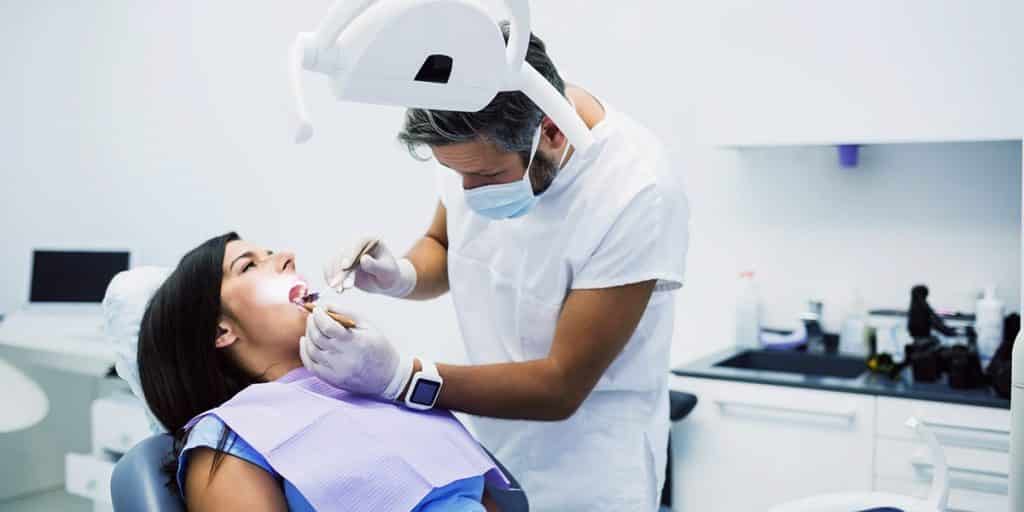 dentista tratando paciente que chegou através do marketing odontológico