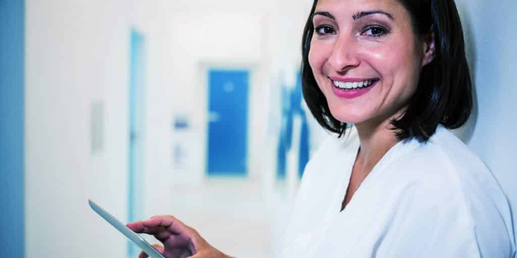 mulher dentista com tablet faz marketing odontológico