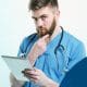 médico de barba usando tablet para pesquisar sobre marketing digital para médicos e palavras-chave
