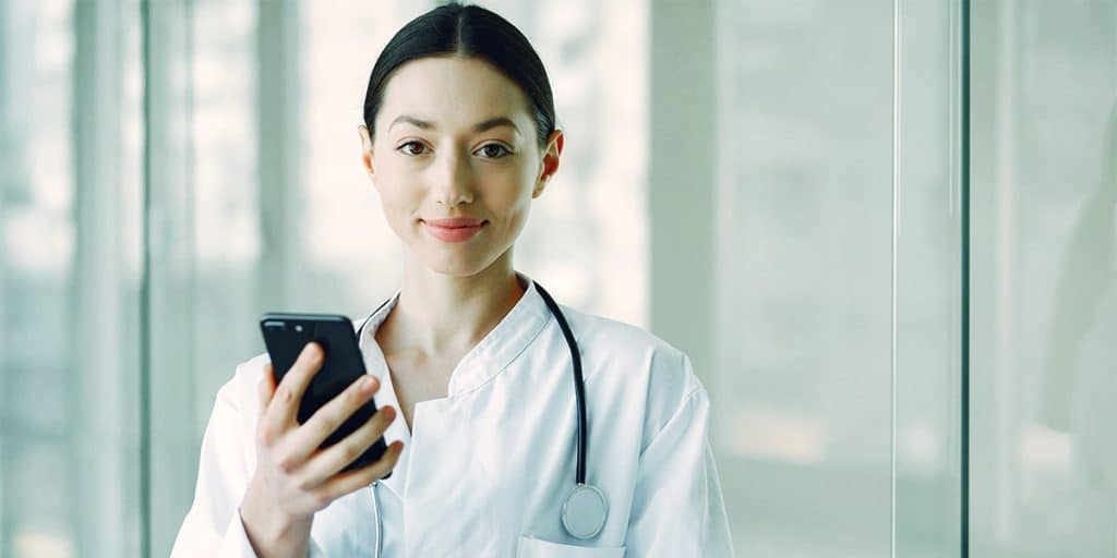 médica com celular bem-sucedida graças às redes sociais