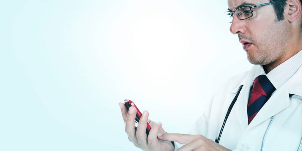 médico usando celular verifica marketing digital médico nas redes sociais