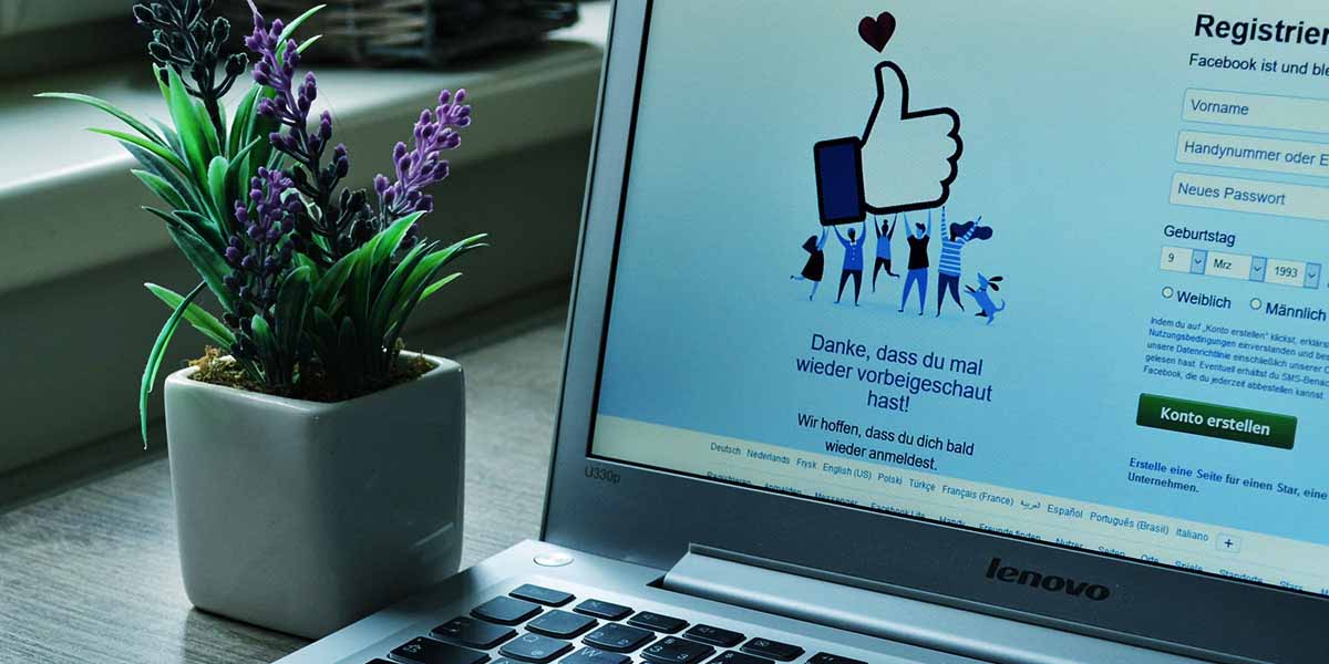 Tela de laptop mostrando logotipo do Facebook - site E-clínica Marketing Digital
