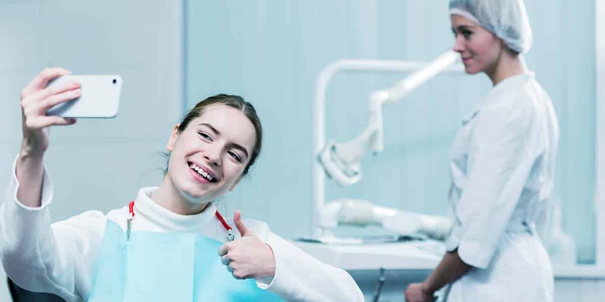 Paciente se filmando durante seu tratamento com a dentista - site E-clínica agência digital